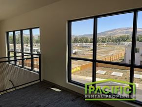 Medford apartment for rent - a living room with large windows and a view of a construction site