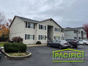 Medford apartment for rent - a white apartment building with cars parked in a parking lot