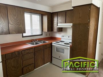 Ashland apartment for rent - A kitchen with wooden cabinets and a stove top oven.