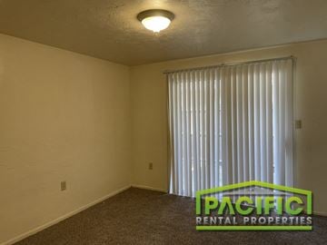 Ashland apartment for rent - the upstairs living room of an apartment with a large window and white curtains