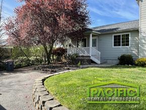 Medford apartment for rent - A house with a driveway and a tree with pink leaves.