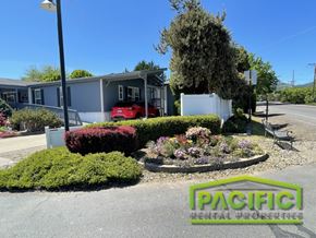 Medford apartment for rent - A red car is parked in front of a house with a sign that says "Pacific Rental Properties".
