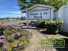 Medford apartment for rent - A sign for Cobblestone Mobile & RV Park with a garden in the foreground.