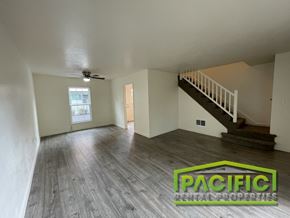 Medford apartment for rent - A spacious room with wooden flooring and a staircase leading to another level.