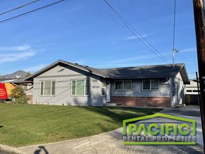 Medford apartment for rent - A house with a lawn in front and a sign that says Pacific Rental Properties.