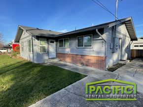 Medford apartment for rent - A house with a lawn in front and a sign that says Pacific Rental Properties.