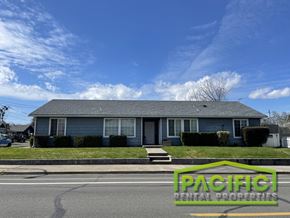 Medford apartment for rent - A house with a grey roof and a sign that says "Pacific Rental Properties".