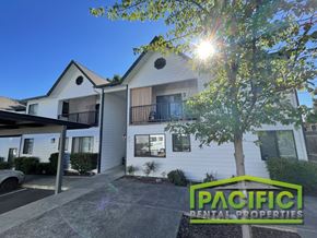 Ashland apartment for rent - A sunny day at a Pacific Rental Properties property with a white house and a tree in the foreground.