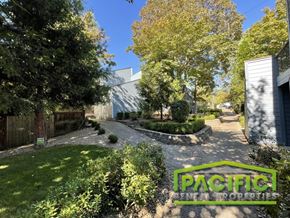 Ashland apartment for rent - A lush green garden with a sign that reads "PACIFIC RENTAL PROPERTIES".