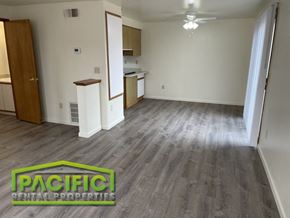Medford apartment for rent - an empty living room with wood flooring and a kitchen