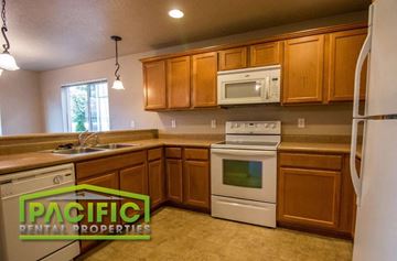 Medford apartment for rent - a kitchen with white appliances and wooden cabinets
