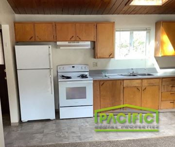 Ashland apartment for rent - a kitchen with white appliances and wooden cabinets