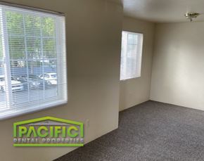 Medford apartment for rent - the interior of an empty living room with a window and a pacific dental props