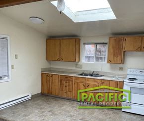 Ashland apartment for rent - an empty kitchen with white appliances and wooden cabinets