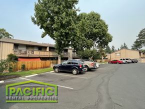 Medford apartment for rent - a parking lot with cars in front of an apartment building
