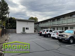 Medford apartment for rent - a parking lot with cars in front of a building