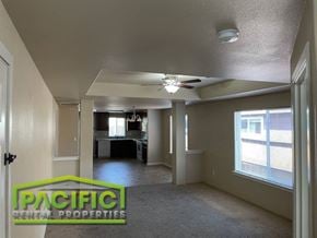 Central Point apartment for rent - an empty living room with a ceiling fan and a kitchen