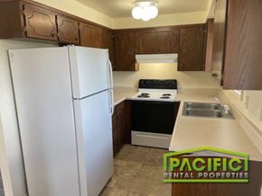 Ashland apartment for rent - a kitchen with white appliances and wooden cabinets and a refrigerator