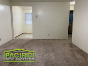 Ashland apartment for rent - the living room and dining room of a new home with carpeting and a door