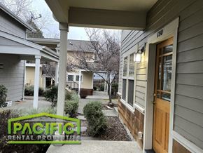 Ashland apartment for rent - a walkway between two houses with a wooden door and a porch