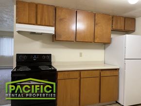 Ashland apartment for rent - a kitchen with wooden cabinets and a stove and a refrigerator