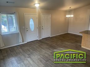 Grants Pass apartment for rent - A room with wooden flooring and two white doors, one of which has a stained glass window.