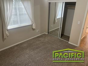 Grants Pass apartment for rent - A room with a carpeted floor and a sliding glass door.