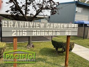Medford apartment for rent - a wooden sign in the grass in front of a house