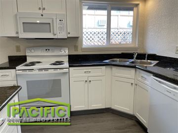 Medford apartment for rent - A kitchen with a stove top oven and a microwave above it.