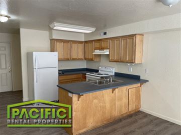 Medford apartment for rent - A kitchen with wooden cabinets and a white refrigerator.