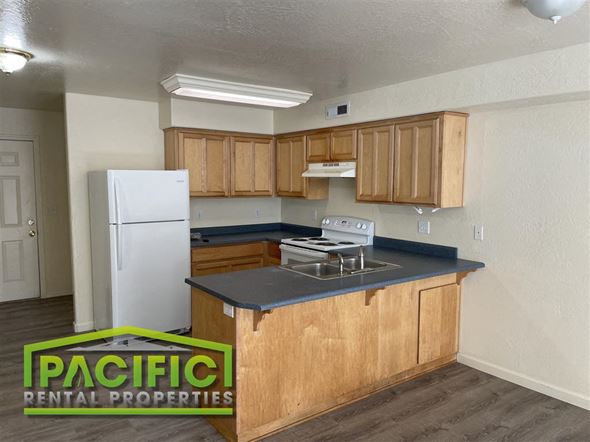 Medford apartment for rent - A kitchen with wooden cabinets and a white refrigerator.