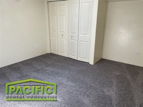 Medford apartment for rent - A room with a grey carpet and a Pacific sign on the floor.