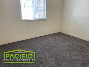 Medford apartment for rent - A room with a grey carpet and a window with blinds.