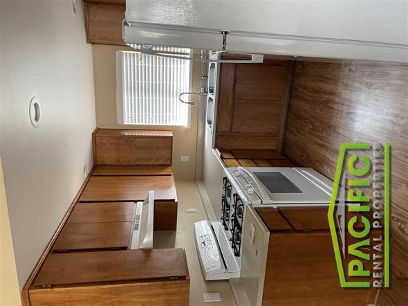 Rogue River apartment for rent - a kitchen with wooden cabinets and a stove top oven