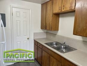 Ashland apartment for rent - a small kitchen with a sink and wooden cabinets