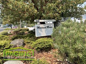 Ashland apartment for rent - a sign in a garden with bushes and trees