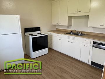 Ashland apartment for rent - a kitchen with white cabinets and appliances and a sink