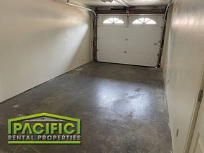 Ashland apartment for rent - A spacious garage with two doors and a logo for Pacific Rental Properties.