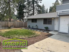 Ashland apartment for rent - A house with a grey roof and a white garage door is surrounded by a wooden fence.