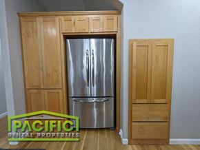 Ashland apartment for rent - a stainless steel refrigerator in a kitchen with wooden cabinets