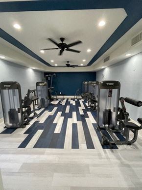 Sacramento apartment for rent - A gym with a variety of equipment including treadmills, weights, and a ceiling fan.