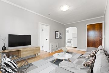 Regina apartment for rent - A living room with a grey couch and a black television.