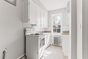 Regina apartment for rent - A kitchen with white cabinets and a stove top oven.