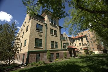 Regina apartment for rent - A large building with a green trim and a balcony on the second floor.