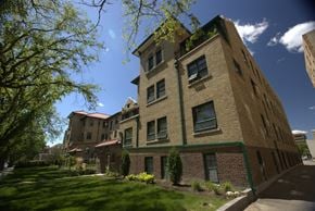 Regina apartment for rent - A tall building with a green trim around the windows and a red roof.