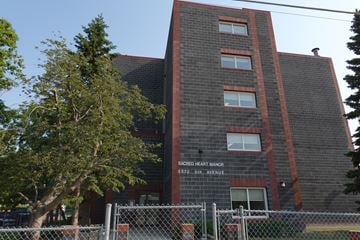 Regina apartment for rent - A brick building with a sign that says Sacred Heart Manor.