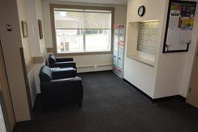 Regina apartment for rent - A waiting room with two chairs and a wall clock.