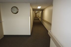 Regina apartment for rent - A long hallway with a clock on the wall.