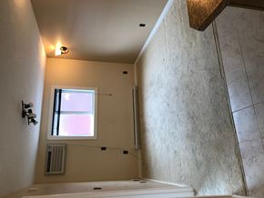 Regina condo for rent - a bathroom with a tub and a window