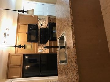 Regina condo for rent - A kitchen with a black refrigerator and a black stove top oven.